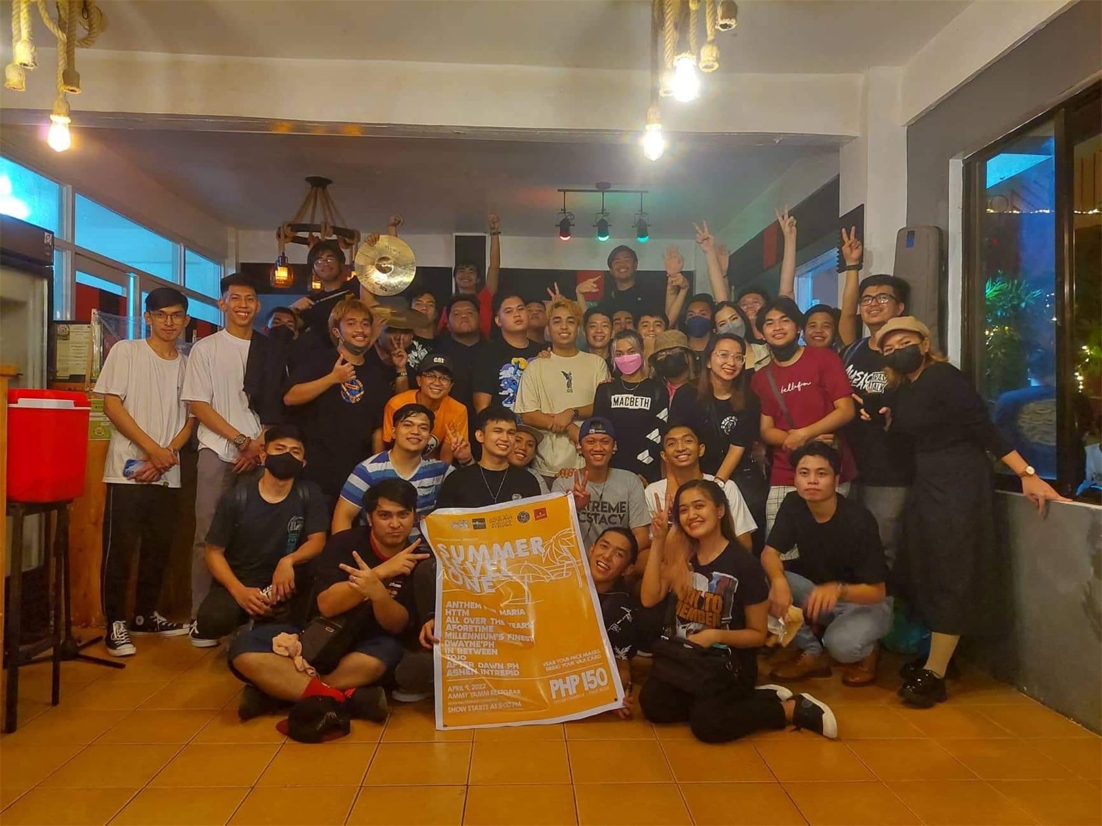 Bands, crew and friends holding the Summer Level One poster at our first gig in 2022